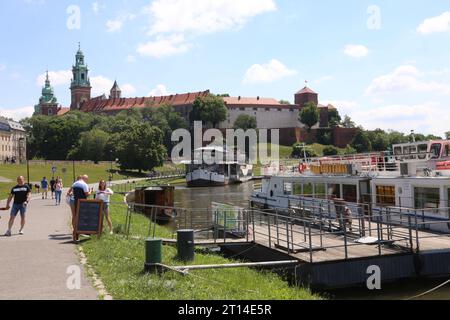 Cracovie. Cracovie. Pologne. Bateaux de plaisance naviguant sur le port de la rivière Vistule et place d'embarquement en face du château royal de Wawel vu dans le backgroun Banque D'Images