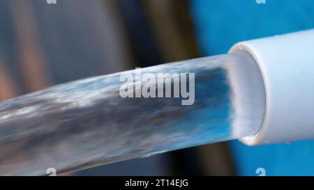 Jet d'eau s'écoule d'une piscine bleue. Banque D'Images