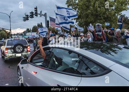 Bellevue, États-Unis. 09 octobre 2023. Le conducteur envoie un message puissant de solidarité tout en naviguant sur le rallye, ajoutant à l’atmosphère de soutien et de paix. Des centaines de partisans israéliens se sont rassemblés à Bellevue, tenant des drapeaux et des pancartes israéliens. Ils se sont réunis pour exprimer leur solidarité au milieu d’une crise qui s’aggrave. Crédit : SOPA Images Limited/Alamy Live News Banque D'Images