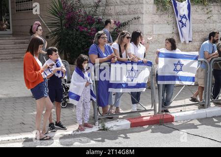 Jérusalem, Israël. 11 octobre 2023. Procession funéraire pour le Sgt Adi Tzur de la brigade Golani de Tsahal quitte la maison familiale alors que des centaines de personnes tapissent la rue avec des drapeaux israéliens pour leur rendre hommage et leur remercier pour son sacrifice. Tzur faisait partie des centaines de disparus suite aux tirs massifs de roquettes depuis la bande de Gaza sur Israël le 7 octobre 2023, à l’infiltration d’hommes armés en territoire israélien, au massacre de femmes et d’enfants civils dans leurs maisons et à la prise d’otages de civils et de soldats. Israël est engagé dans une guerre avec le Hamas de la bande de Gaza. 300 000 réservistes ont été déployés et le si Banque D'Images