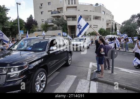 Jérusalem, Israël. 11 octobre 2023. Procession funéraire pour le Sgt Adi Tzur de la brigade Golani de Tsahal quitte la maison familiale alors que des centaines de personnes tapissent la rue avec des drapeaux israéliens pour leur rendre hommage et leur remercier pour son sacrifice. Tzur faisait partie des centaines de disparus suite aux tirs massifs de roquettes depuis la bande de Gaza sur Israël le 7 octobre 2023, à l’infiltration d’hommes armés en territoire israélien, au massacre de femmes et d’enfants civils dans leurs maisons et à la prise d’otages de civils et de soldats. Israël est engagé dans une guerre avec le Hamas de la bande de Gaza. 300 000 réservistes ont été déployés et le si Banque D'Images