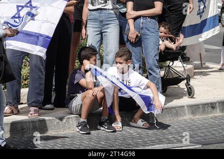 Jérusalem, Israël. 11 octobre 2023. Procession funéraire pour le Sgt Adi Tzur de la brigade Golani de Tsahal quitte la maison familiale alors que des centaines de personnes tapissent la rue avec des drapeaux israéliens pour leur rendre hommage et leur remercier pour son sacrifice. Tzur faisait partie des centaines de disparus suite aux tirs massifs de roquettes depuis la bande de Gaza sur Israël le 7 octobre 2023, à l’infiltration d’hommes armés en territoire israélien, au massacre de femmes et d’enfants civils dans leurs maisons et à la prise d’otages de civils et de soldats. Israël est engagé dans une guerre avec le Hamas de la bande de Gaza. 300 000 réservistes ont été déployés et le si Banque D'Images