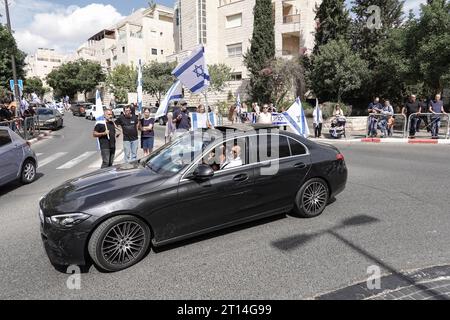 Jérusalem, Israël. 11 octobre 2023. Procession funéraire pour le Sgt Adi Tzur de la brigade Golani de Tsahal quitte la maison familiale alors que des centaines de personnes tapissent la rue avec des drapeaux israéliens pour leur rendre hommage et leur remercier pour son sacrifice. Tzur faisait partie des centaines de disparus suite aux tirs massifs de roquettes depuis la bande de Gaza sur Israël le 7 octobre 2023, à l’infiltration d’hommes armés en territoire israélien, au massacre de femmes et d’enfants civils dans leurs maisons et à la prise d’otages de civils et de soldats. Israël est engagé dans une guerre avec le Hamas de la bande de Gaza. 300 000 réservistes ont été déployés et le si Banque D'Images