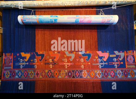 Vue intérieure dans les galeries d'exposition d'un métier à tisser vertical avec un tissage de tapis bleu et rouge. Au Musée du tapis à Bakou, Azerbaïdjan. Banque D'Images