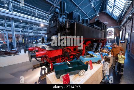 11 octobre 2023, Saxe, Chemnitz : des véhicules pour enfants sont alignés autour d'une locomotive à vapeur historique de classe 98,0 pour une petite exposition spéciale au Musée industriel de Chemnitz. 'Mobile Kindeträume' est le titre de l'émission, qui sera exposée jusqu'au 5 novembre 2023. En coopération avec le collectionneur de véhicules pour enfants Eckart Holler et le dépôt de Pohl-Ströher, la présentation donne un aperçu de plus de 70 ans du monde mobile des enfants. Une gamme inimaginable de créativité, de talent inventif et de savoir-faire technique peut être trouvée dans les voitures miniatures, dont certaines ont été produites comme un... Banque D'Images