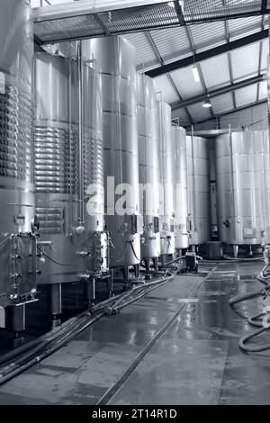 cuves à vin en acier inoxydable pour fermentation dans une installation moderne de cave à vin, photographie en noir et blanc Banque D'Images