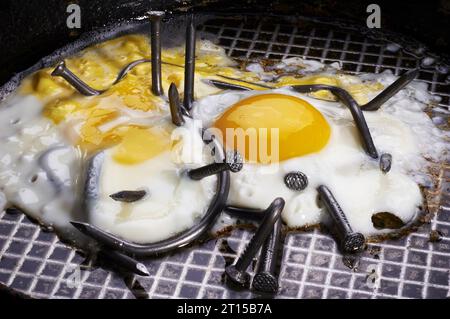 oeufs frits avec des ongles courbés. photo conceptuelle. Banque D'Images