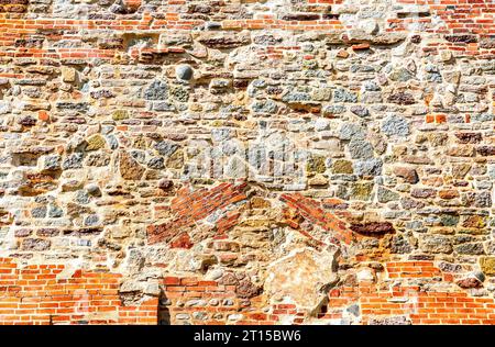 Ancienne brique rouge patinée et mur de pierre de Novgorod Kremlin comme arrière-plan créatif. Fond de texture de mur de brique grunge Banque D'Images