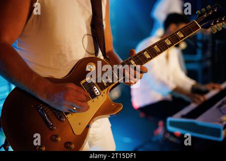 Un gros plan d'un guitariste jouant de leur guitare en direct sur scène. Banque D'Images