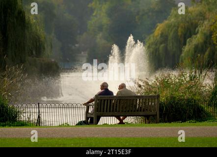 Londres, Royaume-Uni. Deux hommes assis sur un banc à St James's Park Banque D'Images