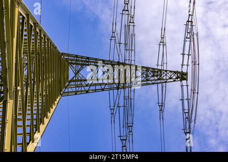 Pylône à haute tension massif et grand pour l'électricité comme ligne électrique pour de nombreuses lignes aériennes contre ciel bleu avec vue vers le haut Banque D'Images