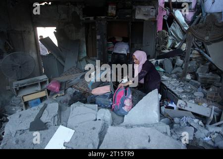 Rafah, Gaza. 11 octobre 2023. Les gens cherchent des biens récupérables après une frappe aérienne israélienne à Rafah, dans le Sud de la bande de Gaza, le mercredi 11 octobre 2023. Les responsables de Gaza ont signalé que plus de 1055 personnes avaient été tuées alors qu’Israël pilonnait le territoire avec des frappes aériennes. Photo par Ismael Mohamad/UPI crédit : UPI/Alamy Live News Banque D'Images