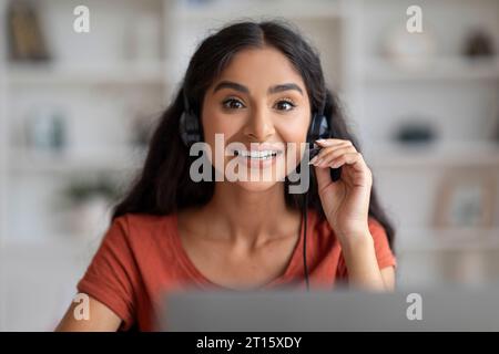 Souriant jeune femme indienne ayant appel web sur ordinateur portable Banque D'Images