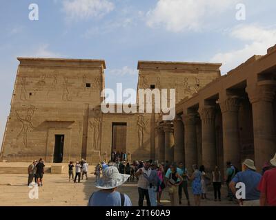 Les touristes visitent le complexe du temple Philae, dédié à la déesse Isis, et admirent les superbes sculptures et hiéroglyphes de l'Égypte ancienne. Banque D'Images