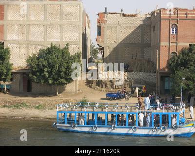 Transport égyptien : un taxi d'eau bleue et blanche prend en charge les passagers d'une petite ville sur les rives est du Nil en haute-Égypte. Banque D'Images