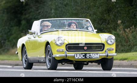 Bicester, Oxon., Royaume-Uni - Oct 8th 2023:1973 MG Midget voiture classique conduisant sur une route de campagne anglaise. Banque D'Images