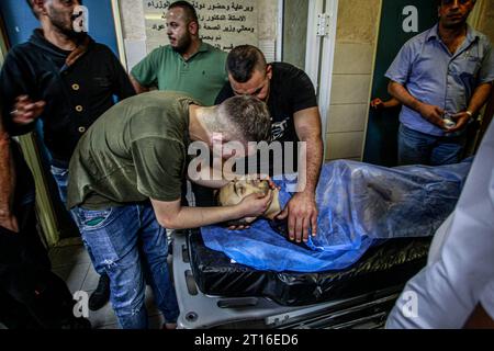 Naplouse, Palestine. 11 octobre 2023. (NOTE DE LA RÉDACTION : l'image représente la mort)des proches pleurent à côté du corps de l'ingénieur palestinien Moaz Odeh, 29 ans, l'un des quatre Palestiniens tués par balles par un groupe de colons juifs armés qui ont attaqué la ville palestinienne de Qasra et assiégé la maison d'une famille. Il a été tué alors qu'il défendait sa famille, dans le nord de la Cisjordanie. Crédit : SOPA Images Limited/Alamy Live News Banque D'Images