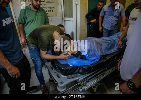 Naplouse, Palestine. 11 octobre 2023. (NOTE DE LA RÉDACTION : l'image représente la mort)des proches pleurent à côté du corps de l'ingénieur palestinien Moaz Odeh, 29 ans, l'un des quatre Palestiniens tués par balles par un groupe de colons juifs armés qui ont attaqué la ville palestinienne de Qasra et assiégé la maison d'une famille. Il a été tué alors qu'il défendait sa famille, dans le nord de la Cisjordanie. (Photo de Nasser Ishtayeh/SOPA Images/Sipa USA) crédit : SIPA USA/Alamy Live News Banque D'Images