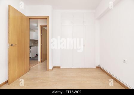 Une pièce vide avec une armoire intégrée avec des portes blanches, des murs lisses fraîchement peints Banque D'Images