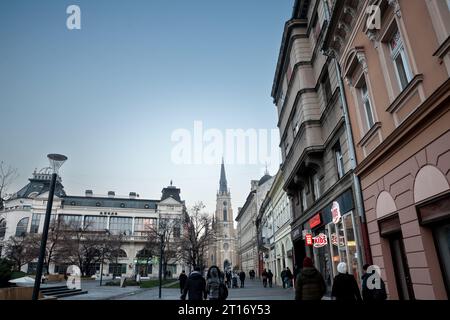 Photo de la cathédrale de Novi Sad avec des piétons passant. L'église du Nom de Marie est une église paroissiale catholique romaine dédiée à la fête de la Banque D'Images