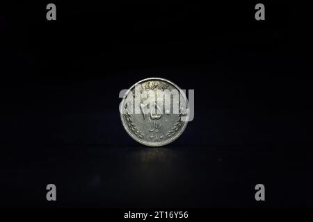 Image d'une pièce iranienne sur fond noir, avec un focus sur une pièce de 250 rians. Le rial est la monnaie officielle de l'Iran. Il est subdivisé int Banque D'Images