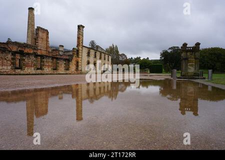 Reflet des ruines du pénitencier dans la flaque de pluie de la destination touristique populaire Port Arthur Historic site, Tasmanie, Australie Banque D'Images