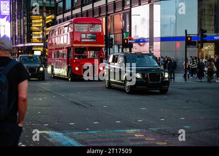 Londres, Angleterre, 05 octobre 2023 : des taxis électriques modernes et un vieux bus à impériale passent devant la station de métro Tottenham court Road. Banque D'Images