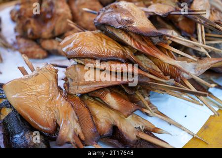 Les raies fumées et grillées embrochées sur des bâtonnets de bambou vendus sur les marchés traditionnels sont prêtes à manger. Pari poisson. Batoidea est un superordre. Banque D'Images