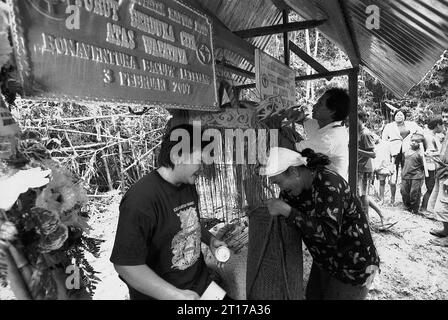 Kalimantan occidental, Indonésie, mars 2007. Les femmes pleurent alors qu’elles déposent des fleurs sur la tombe de leur père, ancien chef traditionnel de la communauté traditionnelle Dayak Tamambaloh, décédé plusieurs semaines plus tôt, dans le village de Sungai Uluk Palin (Sungulo Palin), Putusibau Utara, Kapuas Hulu, Kalimantan occidental, Indonésie. La famille dirigeante de la communauté autochtone Dayak vivant dans la plus longue maison longue de Kalimantan, ils organisent des événements traditionnels en l'honneur de l'ancien chef. plus tard en septembre 2014, leur maison longue a été incendiée par un accident, sans qu'aucun remplacement n'ait été construit. Banque D'Images