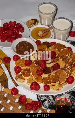 Mini crêpes servies avec, miel, chocolat, beurre de cacahuète et lait. Concept de photographie de menu alimentaire. Prise de vue avec mise au point sélective. Banque D'Images