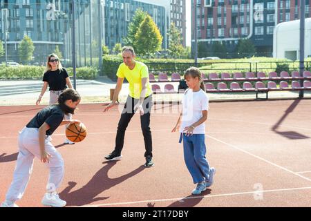 la famille joue au basket-ball sur le terrain Banque D'Images