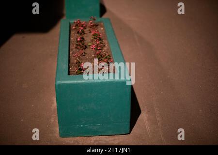 Lit de fleurs en ville la nuit. Parterre de fleurs en béton. Place pour les plantes. Décoration en ville. Détails du parc en soirée. Banque D'Images