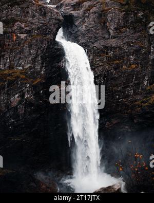 Une cascade luxuriante en cascade sur une surface rocheuse accidentée, entourée de rochers imposants Banque D'Images