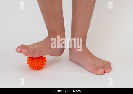 Jambes d'enfant recadrées faisant des exercices avec boule d'aiguille pointue Banque D'Images