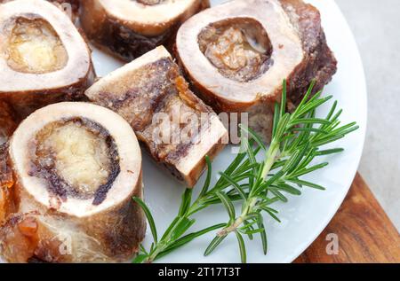 Os de moelle rôtis sur une assiette blanche avec garniture de romarin Banque D'Images
