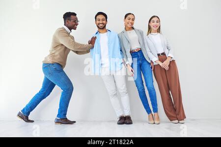 Homme noir poussant l'équipe de gens d'affaires, portrait et sourire au bureau ensemble pour la synergie. Groupe de soutien professionnel solide d'employés Banque D'Images