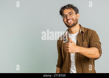J'aime. L'homme indien soulève les pouces vers le haut est d'accord avec quelque chose ou donne une réponse positive recommande la publicité aime la rétroaction de bonne idée, célébrant la victoire de succès. Guy isolé sur fond gris studio Banque D'Images