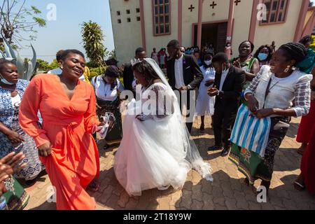 Manica, Mozambique - 09 octobre 2021 : Happy bride dansant avec des invités à l'extérieur de l'église après le mariage Banque D'Images