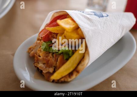 Vue d'un délicieux gyro pita grec rempli de frites, tomate et tzatziki à iOS Grèce Banque D'Images