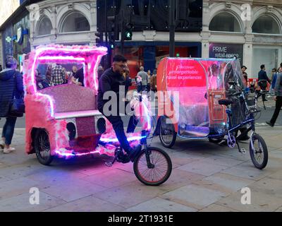 Deux tricycles de taxi tricycles rose moelleux décorés avec goût, attendant les passagers touristiques à Londres Banque D'Images