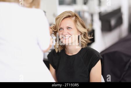 Portrait d'une femme souriante qui a fait ses cheveux boucles Banque D'Images