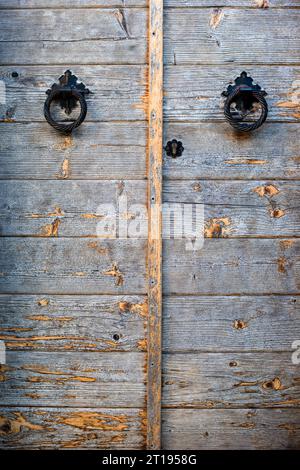 Les doubles portes en bois avec des cogneurs de porte en fer forment l'entrée d'une maison en Grèce. Banque D'Images