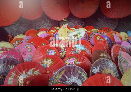 Femmes peignant des parapluies traditionnels en papier, Chiang Mai, Thaïlande Banque D'Images