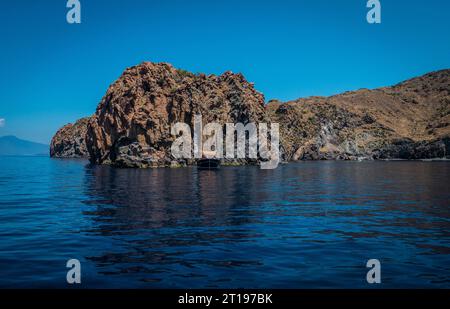 Un petit bateau au milieu d'un plan d'eau. Photo d'un bateau serein flottant dans les eaux cristallines des îles Eolie en Sicile Banque D'Images