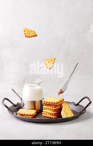 Pile de craquelins et de lait sur un plateau en métal avec un couteau recouvert de caramel Banque D'Images