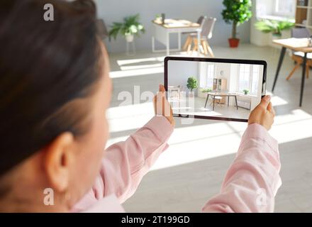 Agent immobilier féminin faisant visite virtuelle du bureau en utilisant sa tablette numérique. Banque D'Images