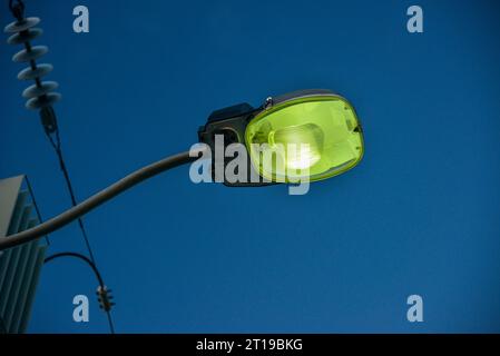 Vue rapprochée d'un lampadaire à vapeur de sodium (vert), avec un ciel bleu en arrière-plan Banque D'Images