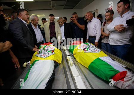 Des Palestiniens portent les corps d'Ibrahim Wadi, 62 ans, et son fils Ahmad Wadi, 25 ans, des Palestiniens portent les corps d'Ibrahim Wadi, 62 ans, et son fils Ahmad Wadi, 25 ans, deux des quatre Palestiniens tués par des colons juifs la veille, lors de leurs funérailles dans la ville de Naplouse en Cisjordanie le 12 octobre 2023. Au moins quatre Palestiniens ont été tués le 11 octobre 2023, alors que des colons israéliens armés attaquaient une ville au sud de Naplouse, en Cisjordanie occupée, a déclaré le ministère palestinien de la Santé. Photo de Mohammed Nasser apaimages Naplouse Cisjordanie territoire palestinien 12102 Banque D'Images