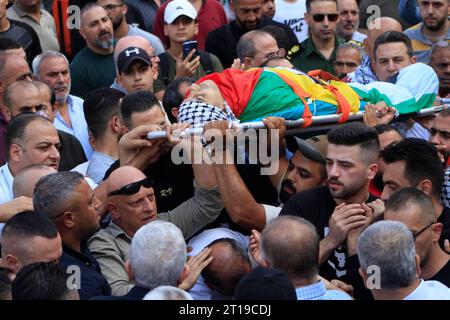 Des Palestiniens portent les corps d'Ibrahim Wadi, 62 ans, et son fils Ahmad Wadi, 25 ans, des Palestiniens portent les corps d'Ibrahim Wadi, 62 ans, et son fils Ahmad Wadi, 25 ans, deux des quatre Palestiniens tués par des colons juifs la veille, lors de leurs funérailles dans la ville de Naplouse en Cisjordanie le 12 octobre 2023. Au moins quatre Palestiniens ont été tués le 11 octobre 2023, alors que des colons israéliens armés attaquaient une ville au sud de Naplouse, en Cisjordanie occupée, a déclaré le ministère palestinien de la Santé. Photo de Mohammed Nasser apaimages Naplouse Cisjordanie territoire palestinien 12102 Banque D'Images