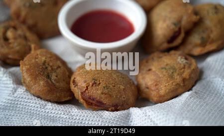 Piaju piajia frit comme installateur d'oignons sur une plaque en céramique décorée. Pakodi frit ou pakoda Banque D'Images